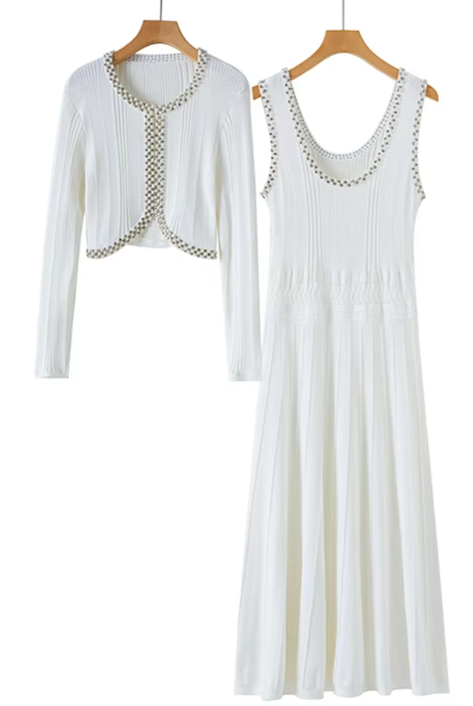 A matching two-piece women's outfit set hanging on wooden hangers against a plain white background. The set includes a sleeveless white ribbed maxi dress with decorative beaded trim along the scoop neckline and a matching cropped open-front cardigan with long sleeves and beaded trim along the edges.