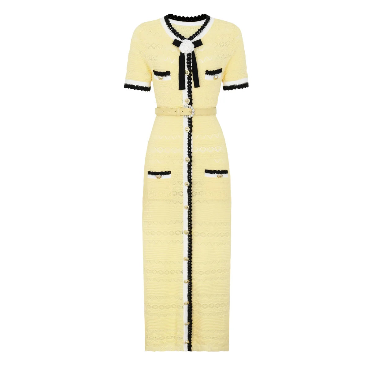 A pale yellow tweed midi dress with black and white trim, featuring a short-sleeve design, a black bow at the collar, a matching waist belt, and decorative buttons down the front.