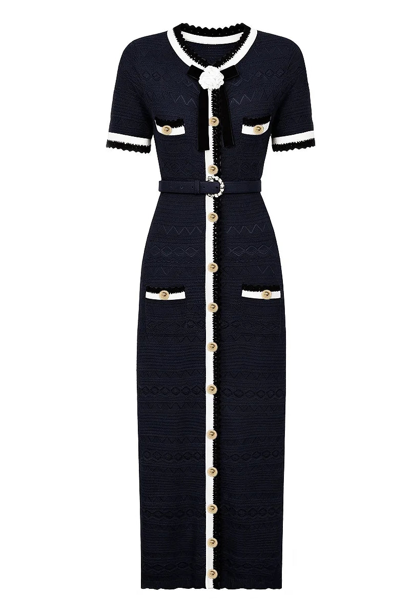 A short-sleeve knit maxi dress in navy blue with white trim and gold-tone button accents, shown on a plain white background.