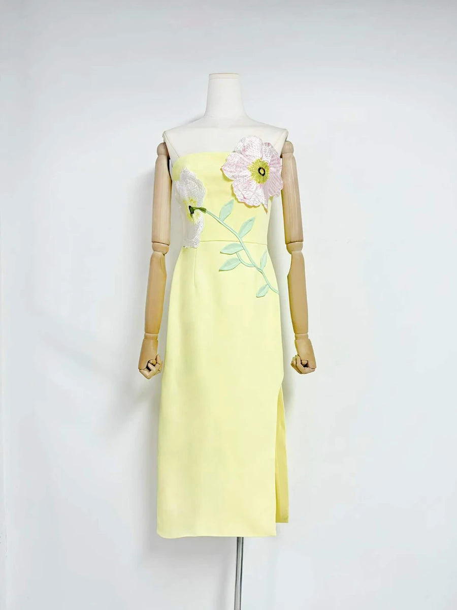 Yellow dress with floral design on a mannequin against a white background