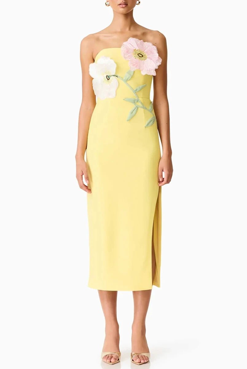 Yellow strapless dress with floral embellishments on a white background