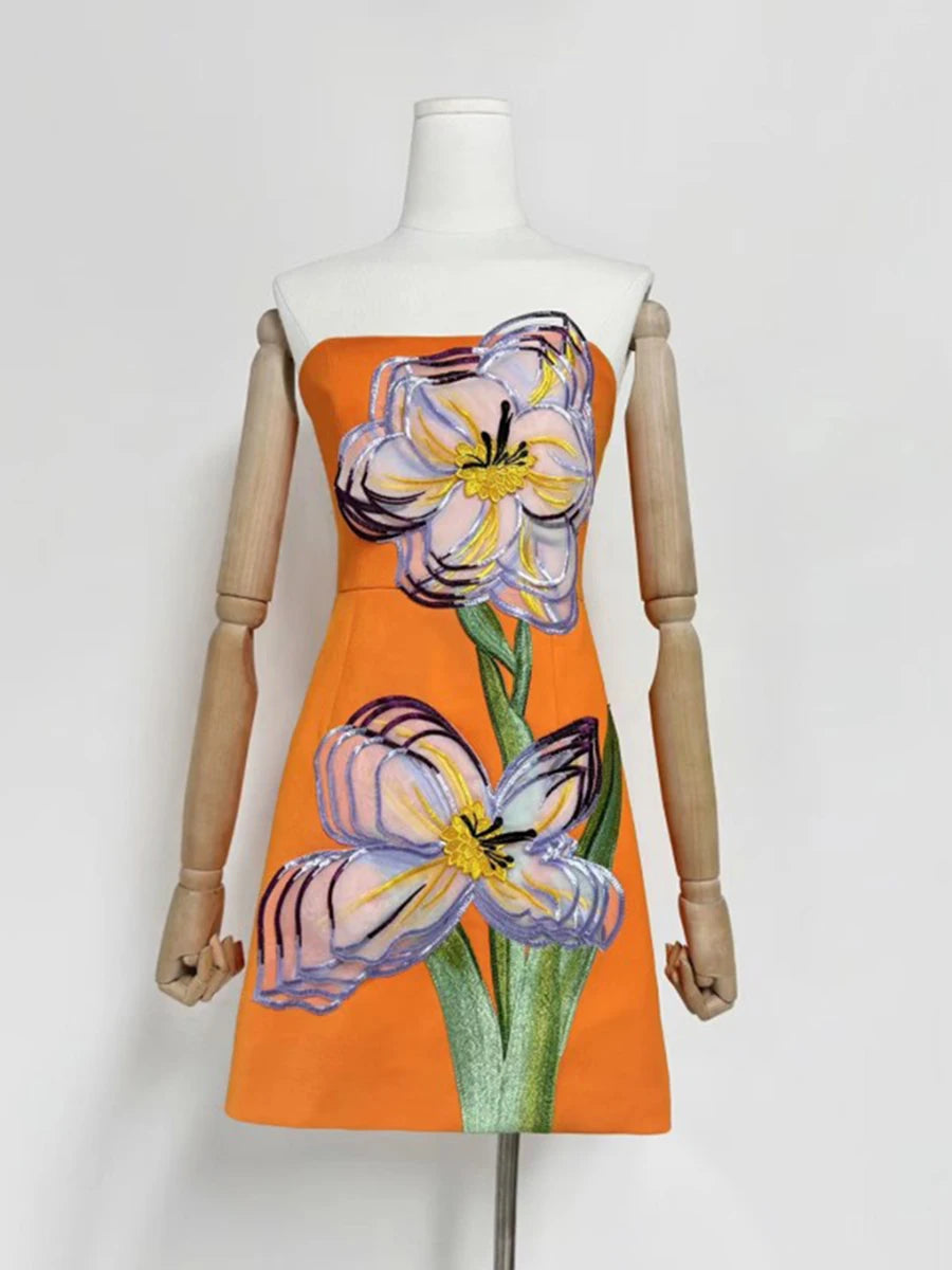 Orange dress with floral design on a mannequin against a white background