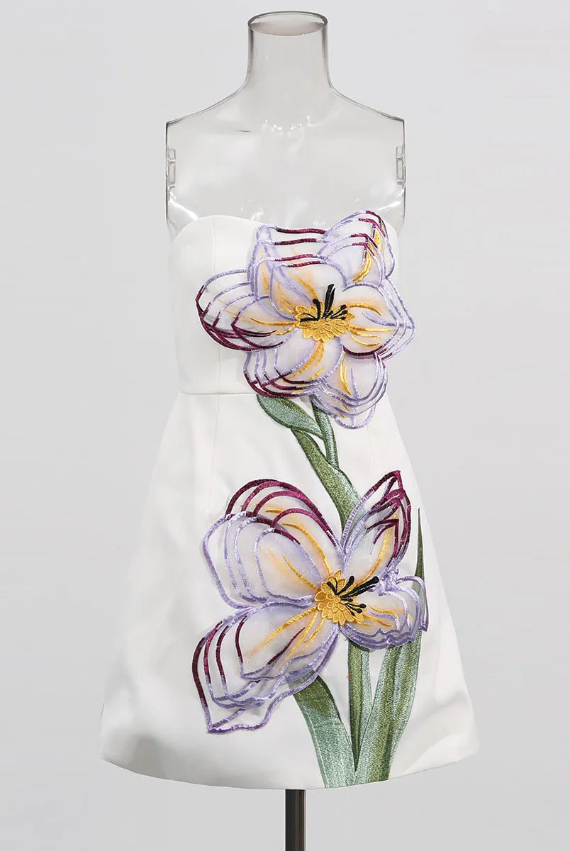 White dress with floral design on a mannequin against a white background
