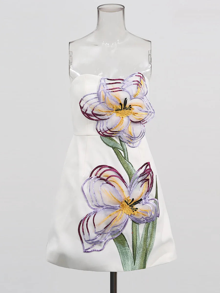 White dress with floral design on a mannequin against a white background