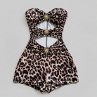 Leopard print swimsuit romper with gold accents on a gray background