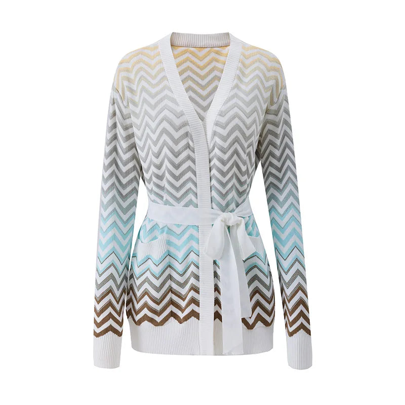 A women's long-sleeve knit cardigan with a V-neck and self-tie belt, featuring a chevron pattern that transitions from white and gray at the top to light blue and brown at the bottom, shown on a plain white background.