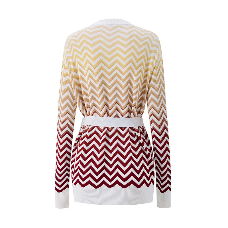A long-sleeve knit cardigan shown from the back, featuring a chevron pattern that fades from cream and beige at the top to deep burgundy at the bottom, finished with a matching white belt.