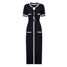 A short-sleeve knit maxi dress in navy blue with white trim and gold-tone button accents, shown on a plain white background.