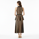 A woman stands with her back to the camera wearing a sleeveless, high-neck outfit set with vertical brown, black, and beige stripes. The dress features a peplum waist and a matching striped belt.