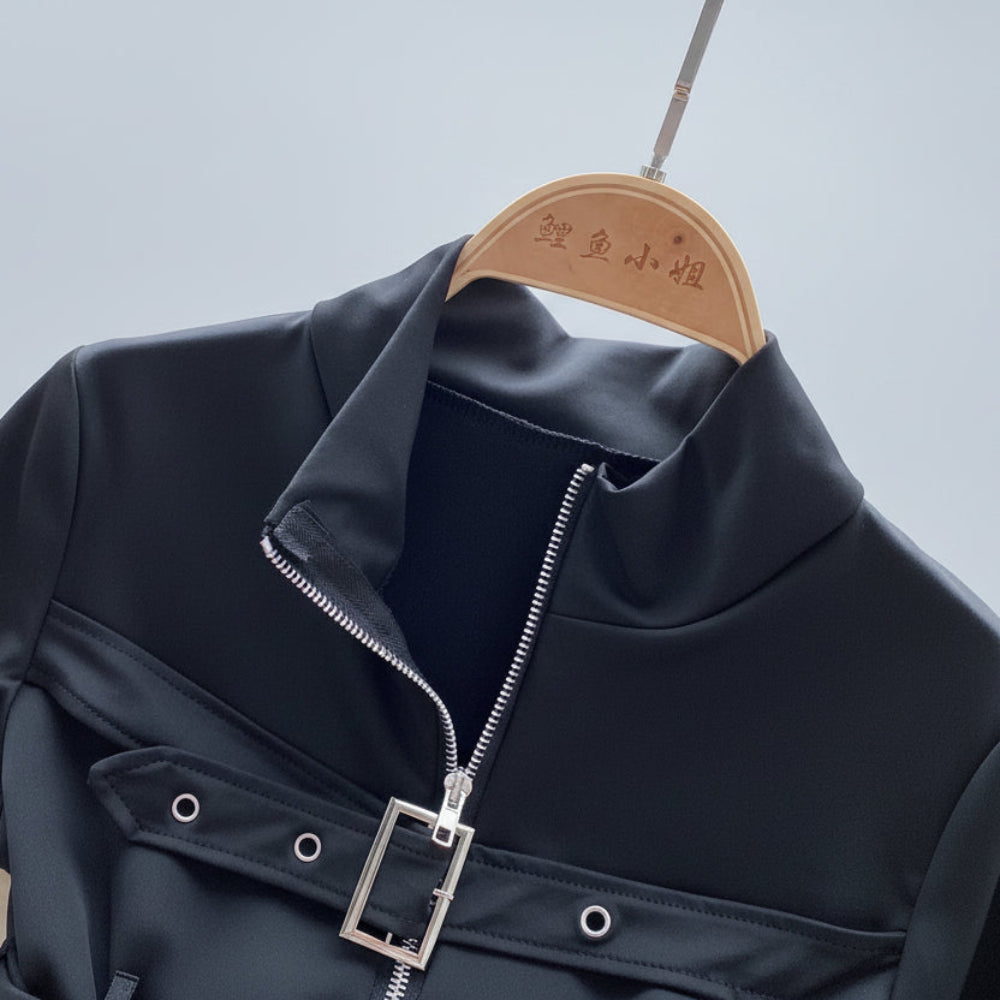 Black bodysuit with a silver buckle on a wooden hanger against a light blue background