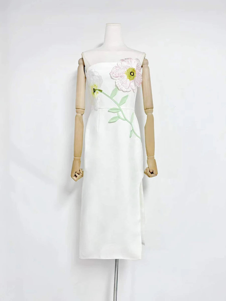 White dress with floral embroidery on a mannequin against a white background