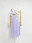 Lavender dress with floral embroidery on a mannequin against a white background
